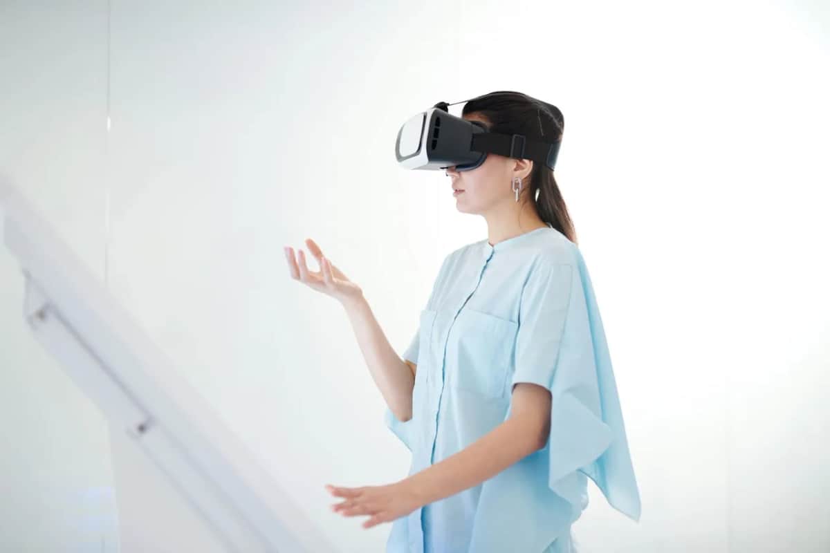 Молода жінка у VR-окулярах взаємодіє з віртуальною реальністю