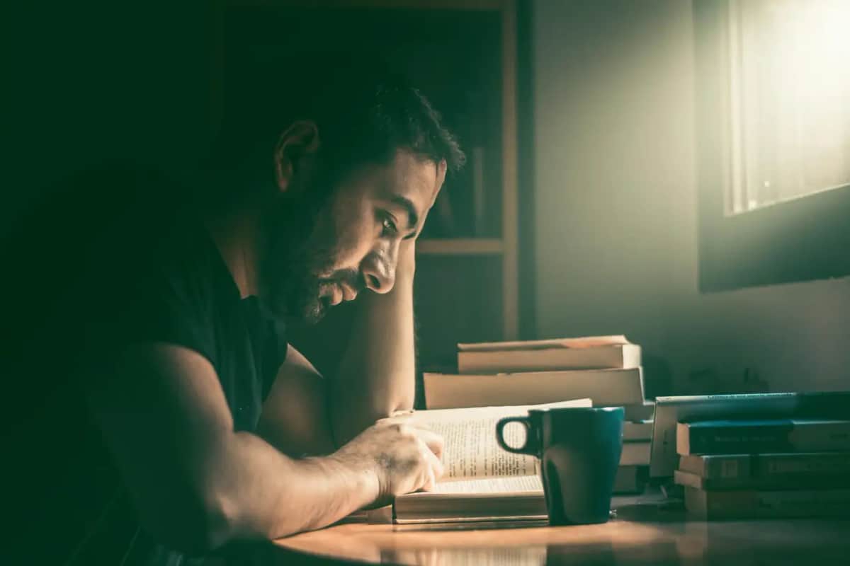 Чоловік зосереджено читає книжку серед стосів книжок — що глибше входиш у тему, то ясніше бачиш межі власного знання