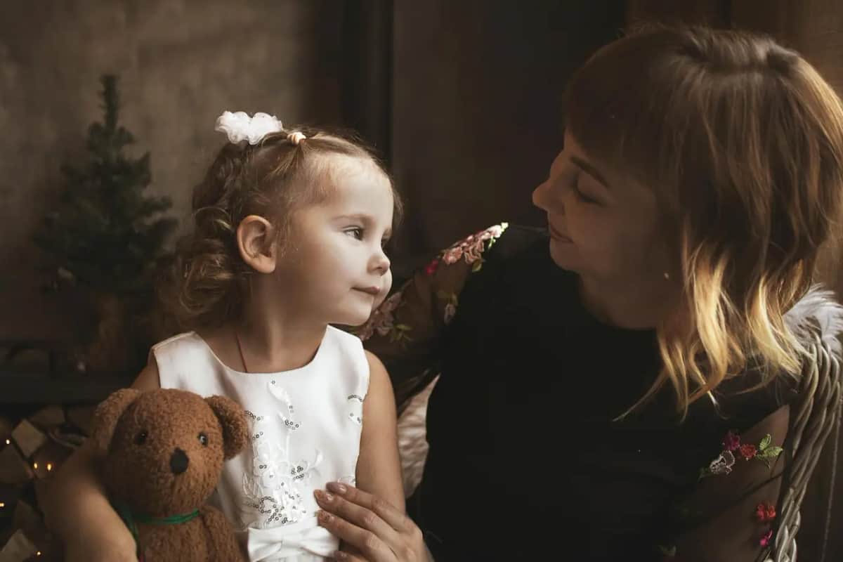 Мама й донька дивляться одна на одну на одному рівні очей під час теплої розмови